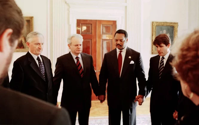 Jackson holds hands with Yugoslavian President Slobodan Milosevic, left, and US Rep. Rod Blagojevich, right, as he leads a prayer in Belgrade, Yugoslavia, in May 1999. Jackson successfully negotiated the release of three US soldiers who had been held in Yugoslavia for more than a month. John H. White/Chicago Sun-Times/Pool/AP