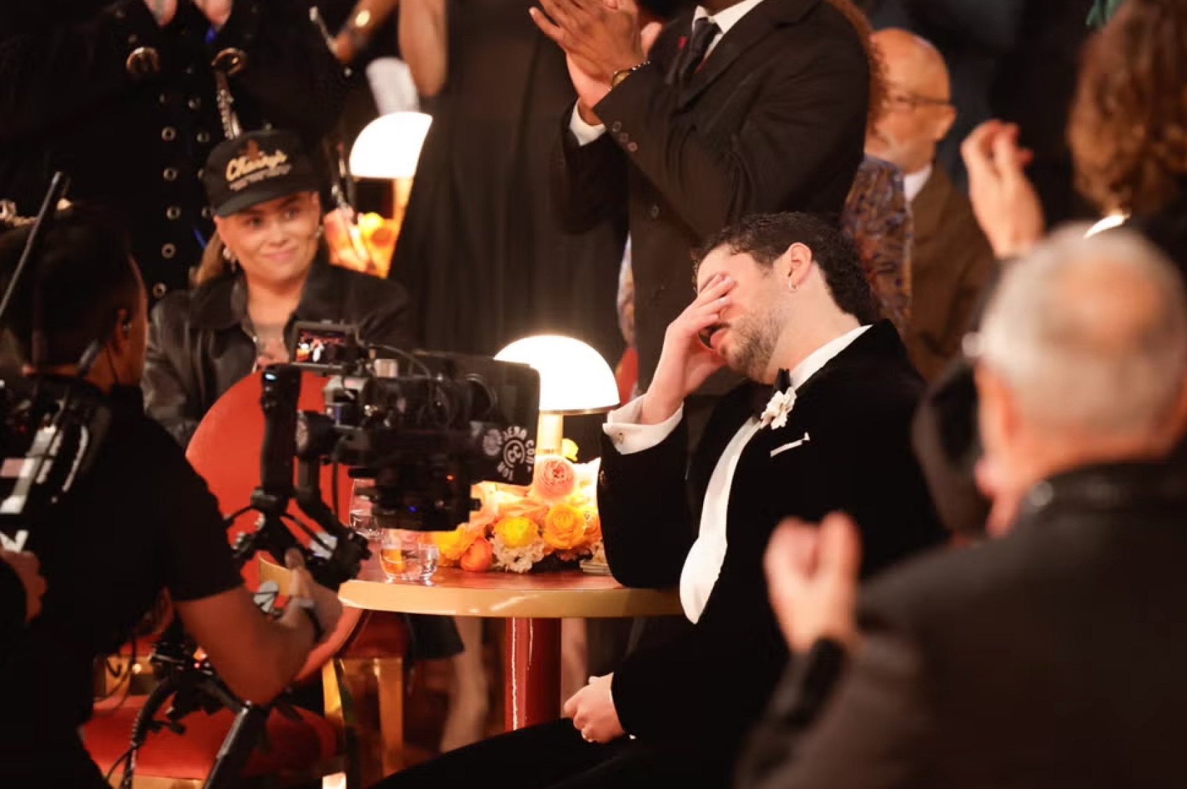LOS ANGELES, CA – FEBRUARY 2026: Bad Bunny reacts emotionally at his table moments after being announced as the winner of Album of the Year for DeBÍ TiRAR MáS FOToS at the 2026 Grammy Awards. The Puerto Rican star, dressed in a custom velvet Schiaparelli tuxedo, covered his face as applause filled the hall, marking a historic win for the first all-Spanish-language album to claim the top prize. | Getty Images