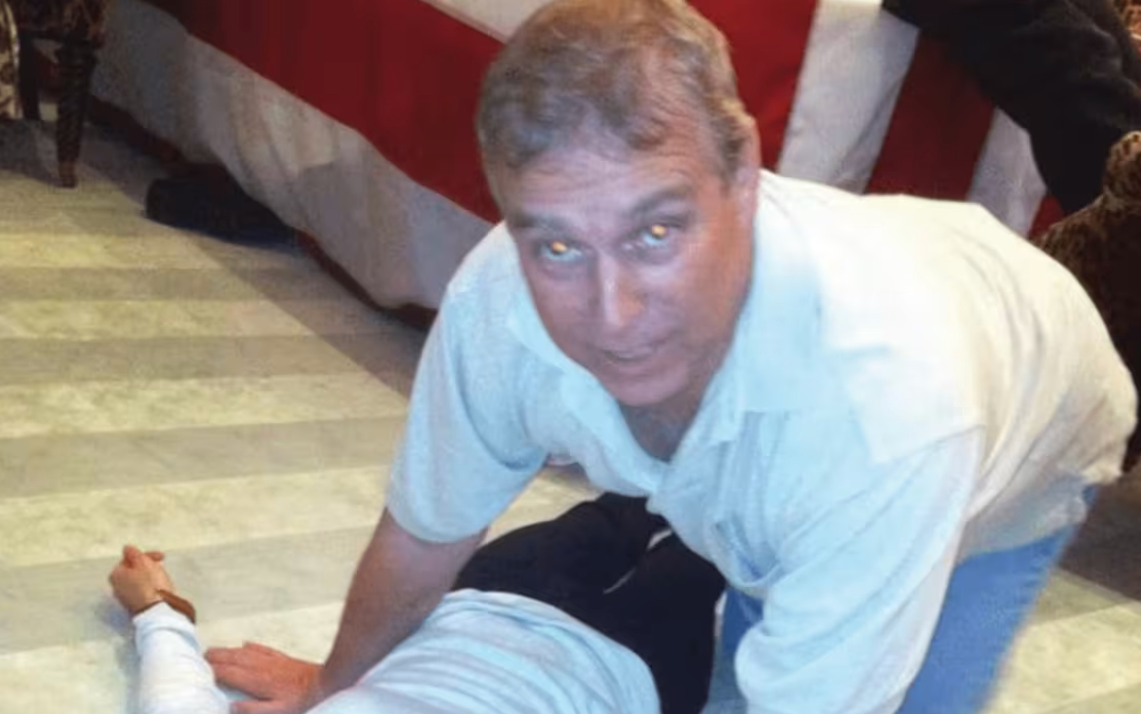 A photograph from an Epstein document release appears to show then-Prince Andrew kneeling over an unknown female. | US Department of Justice