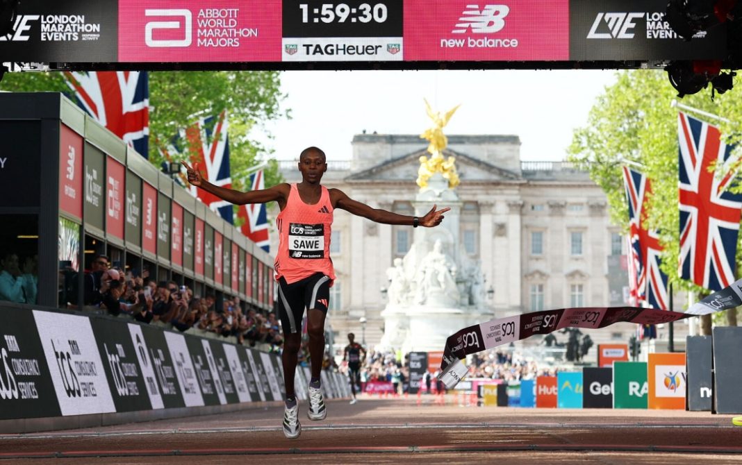 Sabastian Sawe celebrates crossing the line and winning with a new world record at the London Marathon