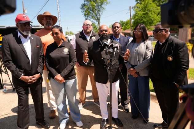 Flanked by city officials, councilman James Gre