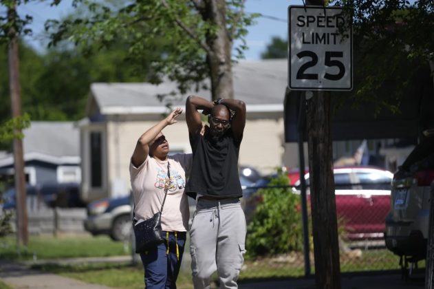 People react outside the scene of the shooting.