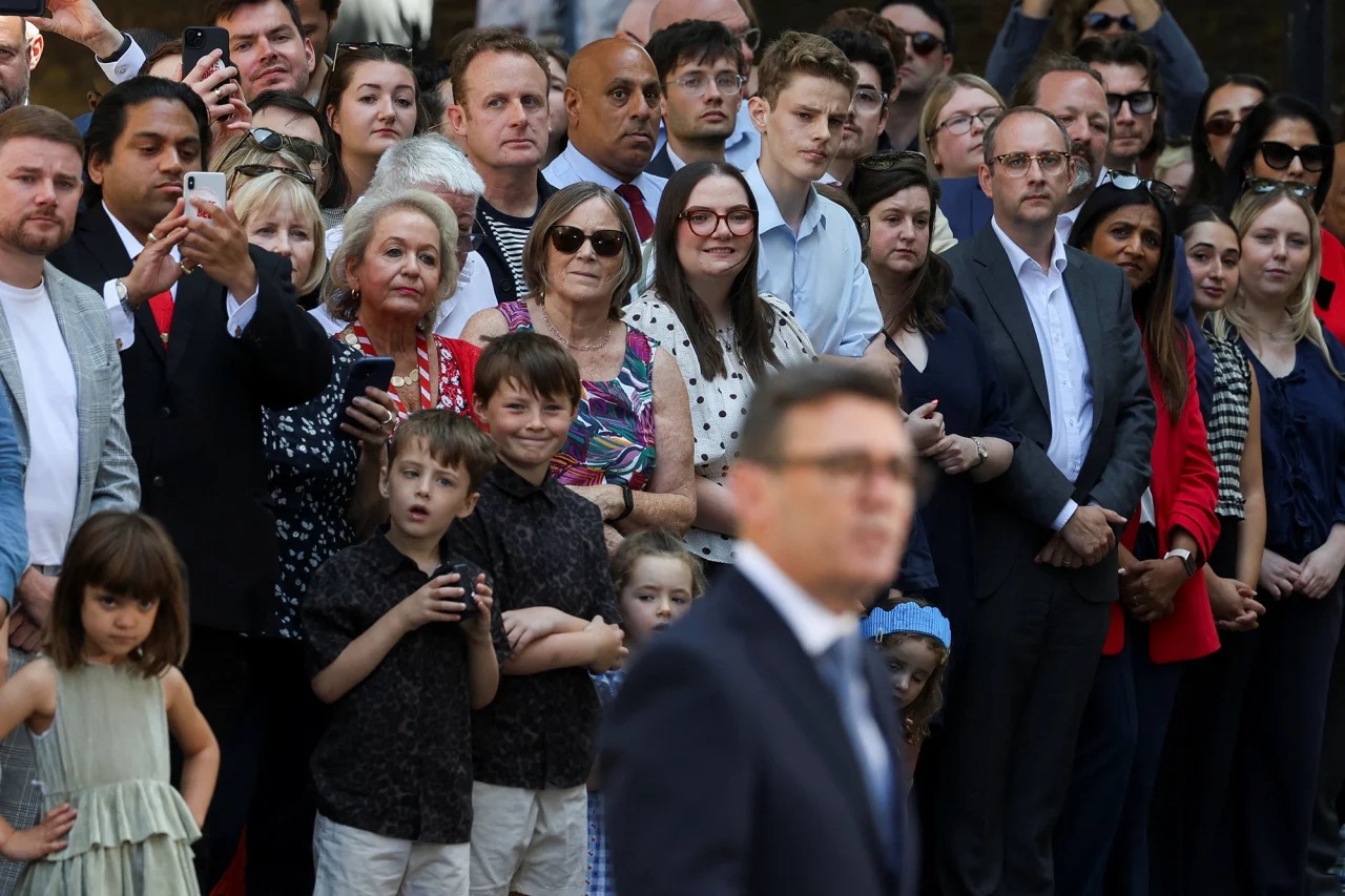 Supporters look on as Britain’s newly appointed Prime Minister Andy Burnham speaks outside 10 Downing Street after taking office in London on July 20, 2026.