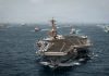 US Strikes 3 Iranian Oil Tankers as Battle Over Strait of Hormuz Deepens A U.S. Navy aircraft carrier sails with escort vessels during maritime operations in waters near the Strait of Hormuz in an undated handout photograph.
