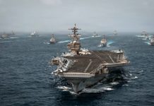 US Strikes 3 Iranian Oil Tankers as Battle Over Strait of Hormuz Deepens A U.S. Navy aircraft carrier sails with escort vessels during maritime operations in waters near the Strait of Hormuz in an undated handout photograph.