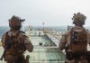 Iran Widens Strikes Across Gulf as U.S. Targets Bridges and Port Tower U.S. troops stand guard aboard an oil tanker during a maritime security operation near the Strait of Hormuz in an undated handout photograph.