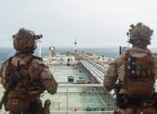 Iran Widens Strikes Across Gulf as U.S. Targets Bridges and Port Tower U.S. troops stand guard aboard an oil tanker during a maritime security operation near the Strait of Hormuz in an undated handout photograph.