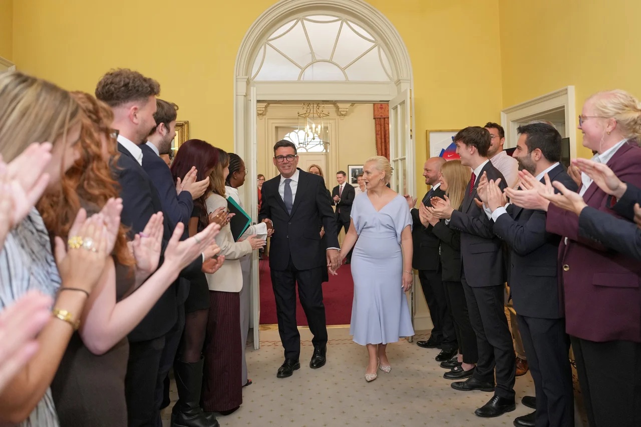Staff clap as new Prime Minister Andy Burnham and wife Marie-France van Heel walk into 10 Downing Street on Monday, July 20. Kin Cheung/PA/AP