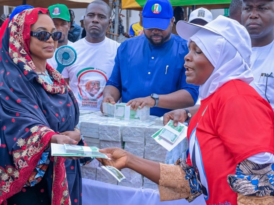 Hajiya Maryam Wadada, wife of Nasarawa APC governorship candidate Senator Ahmed Wadada, appears to hand cash to a woman during the launch of the Hajiya Maryam Ahmed Wadada Aliyu Women Empowerment Scheme in Lafia, Nasarawa State, on August 10, 2026. | The Trent Illustration