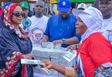 Nasarawa APC Governorship Candidate’s Wife’s Cash Distribution Raises Naira Abuse Concerns Hajiya Maryam Wadada, wife of Nasarawa APC governorship candidate Senator Ahmed Wadada, appears to hand cash to a woman during the launch of the Hajiya Maryam Ahmed Wadada Aliyu Women Empowerment Scheme in Lafia, Nasarawa State, on August 10, 2026. | The Trent Illustration
