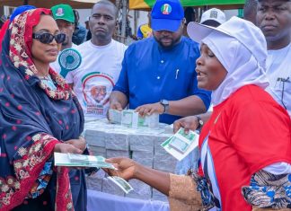 Nasarawa APC Governorship Candidate’s Wife’s Cash Distribution Raises Naira Abuse Concerns Hajiya Maryam Wadada, wife of Nasarawa APC governorship candidate Senator Ahmed Wadada, appears to hand cash to a woman during the launch of the Hajiya Maryam Ahmed Wadada Aliyu Women Empowerment Scheme in Lafia, Nasarawa State, on August 10, 2026. | The Trent Illustration