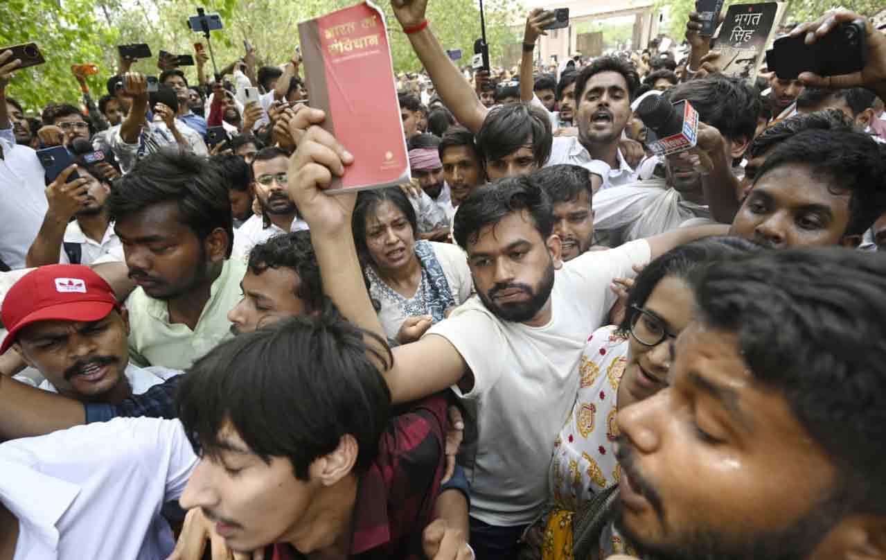 Cockroach Janta Party founder Abhijeet Dipke raises a copy of India’s constitution during a protest demanding the resignation of Union Education Minister Dharmendra Pradhan over alleged examination-related lapses at Eco Garden in Lucknow, Uttar Pradesh, on June 12, 2026. | ANI via Reuters Connect