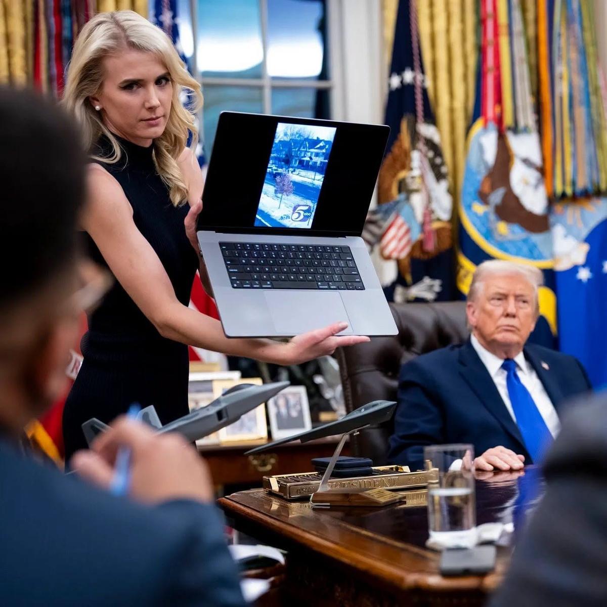 President Donald Trump watches as aide Natalie Harp displays a laptop showing a news report during a press conference with Elon Musk in the Oval Office of the White House in Washington, D.C., Friday, May 30, 2025.