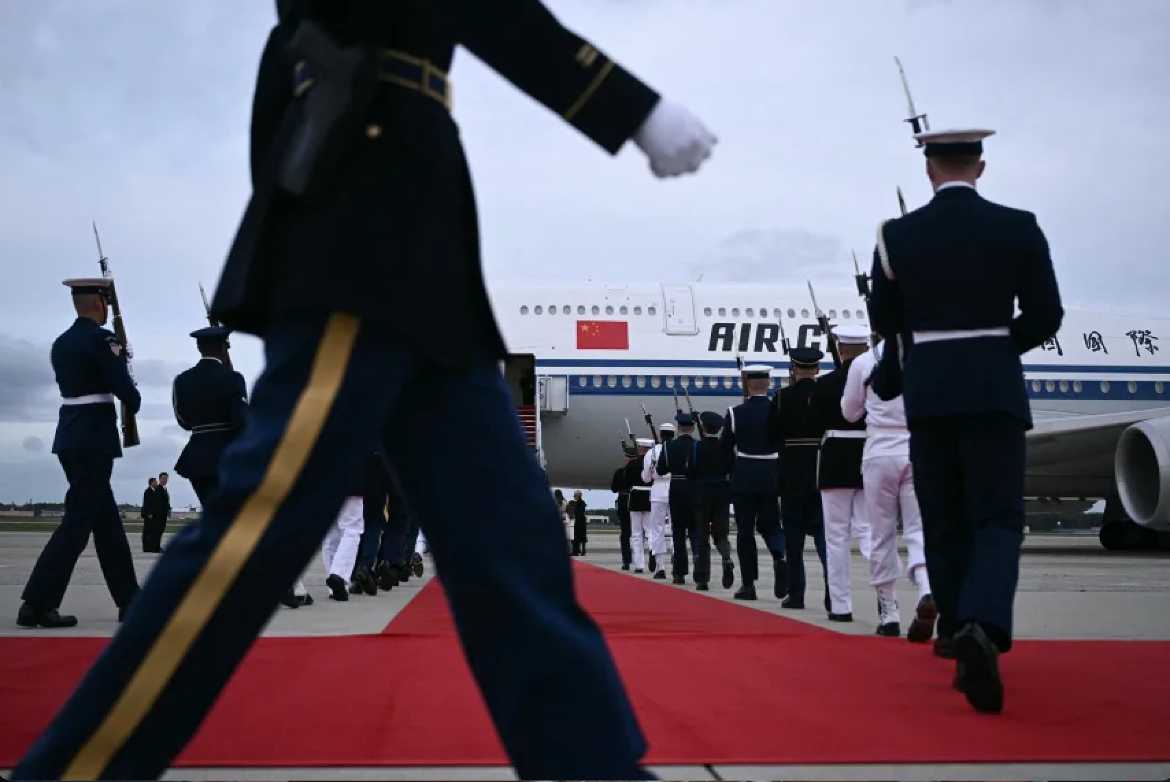 US military personnel walk into position next to a red carpet at the bottom of the stairs of an Air China plane carrying Chinese President Xi as he arrives at Joint Base Andrews, Maryland, on Wednesday,