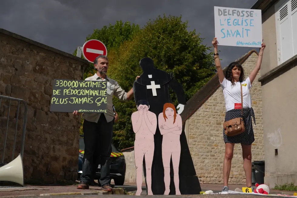 Activists fighting child abuse stage a protest near the home of a former Catholic priest suspected