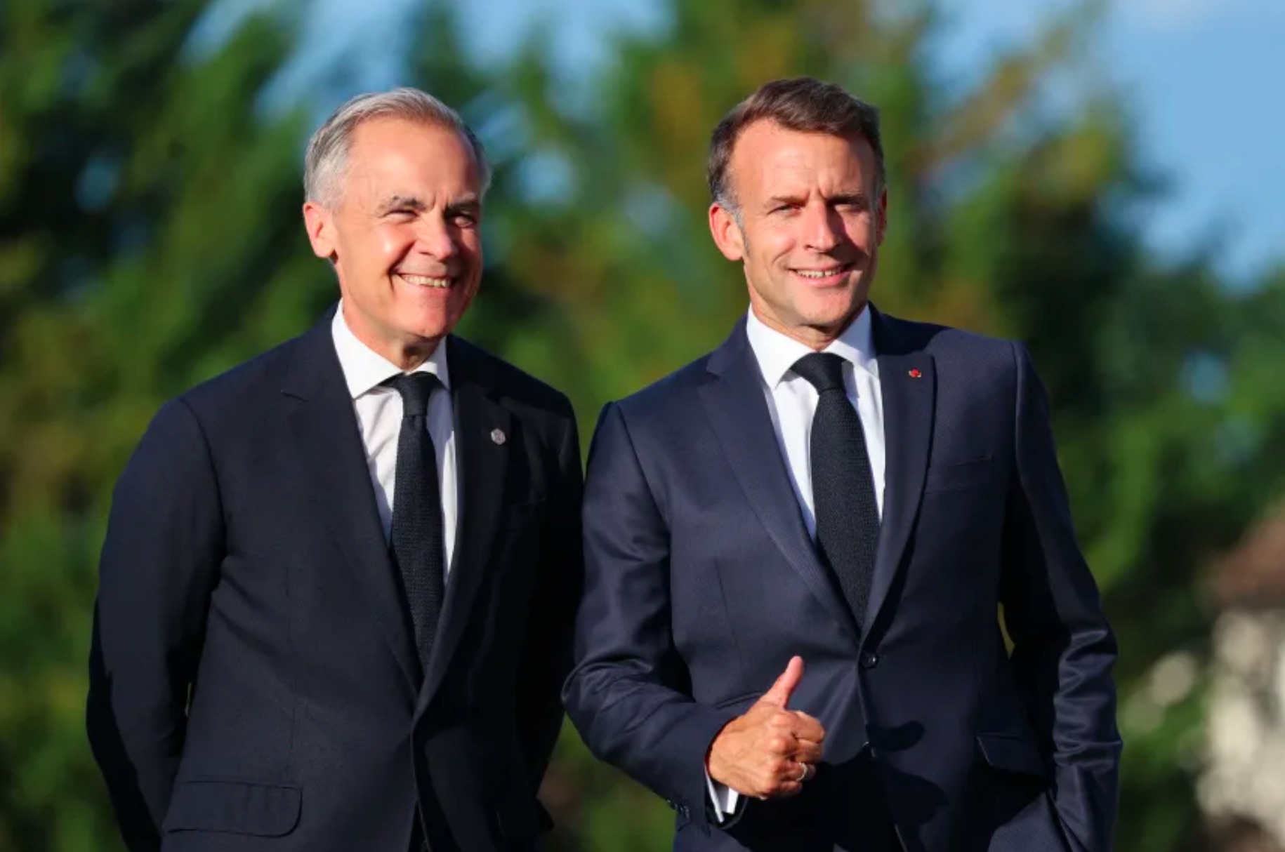 French President Emmanuel Macron (R) gestures as he greets Canadian Prime Minister Mark Carney during the G7 summit, in Evian, France, on June 15. Ludovic Marin/AFP/Getty Images