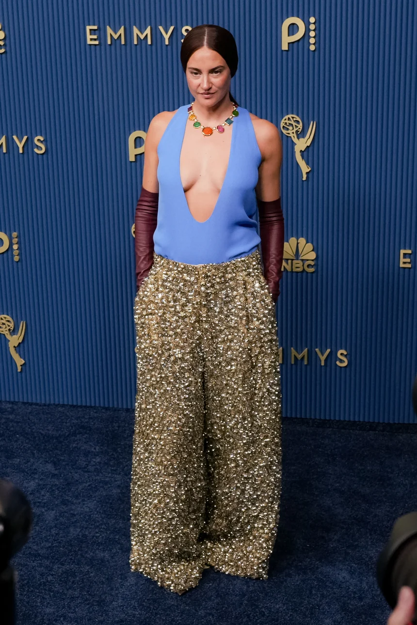 Shailene Woodley attends the 78th Primetime Emmy Awards at the Peacock Theater in Los Angeles on September 14, 2026, wearing a Balenciaga Fall 2026 Couture look featuring a plunging periwinkle top, gold sequinned trousers, and burgundy opera gloves. | 