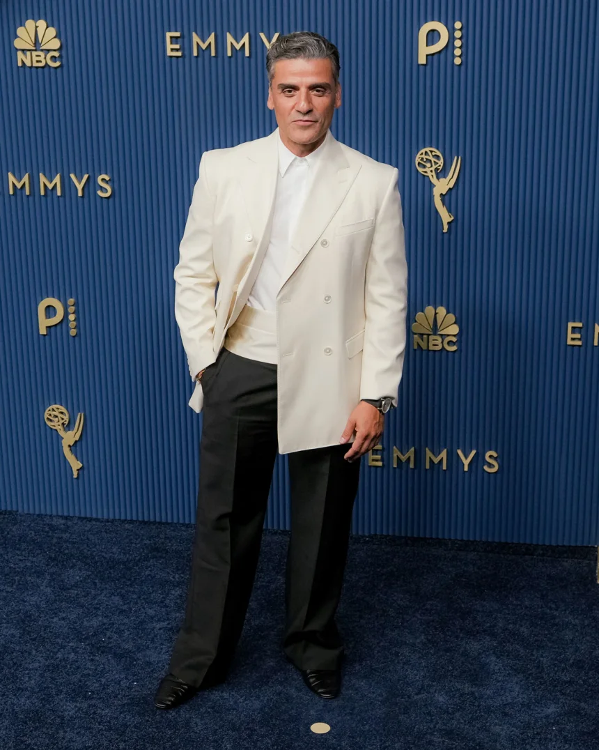 Oscar Isaac attends the 78th Primetime Emmy Awards at the Peacock Theater in Los Angeles on September 14, 2026, wearing a Celine suit featuring a white double-breasted jacket and matching silk cummerbund. |