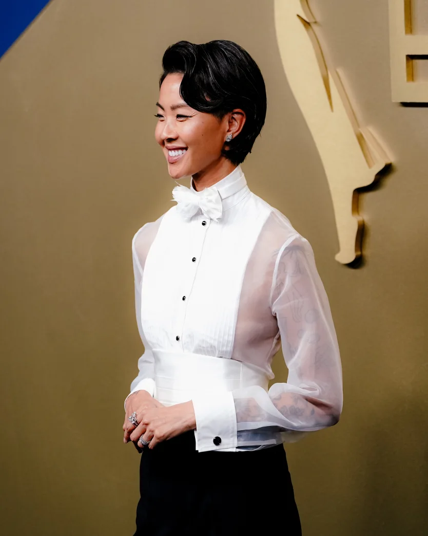 “Top Chef” host Kristen Kish attends the 78th Primetime Emmy Awards at the Peacock Theater in Los Angeles on September 14, 2026, wearing a tuxedo-inspired look with sheer sleeves and a silk cummerbund. | 